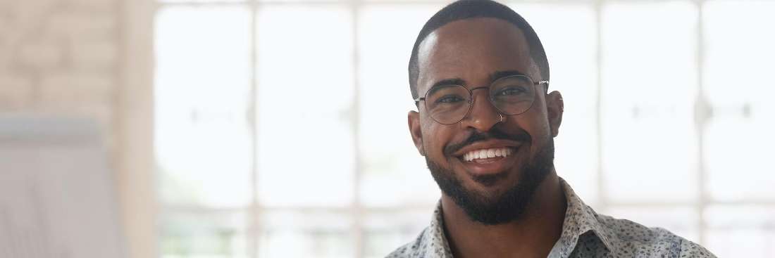 A bearded black man in St. Cloud shows off his teeth with veneers
