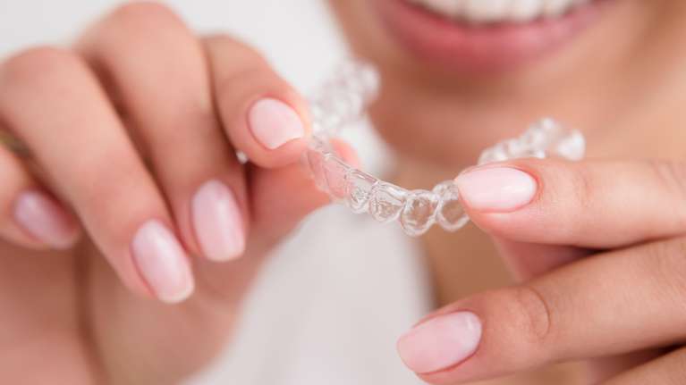 A woman holds clear aligners in St. Cloud FL
