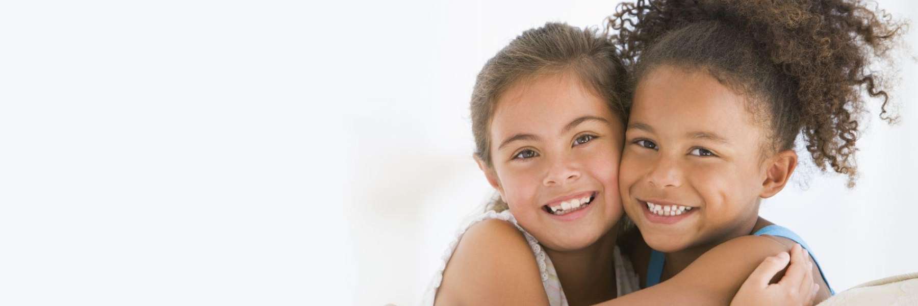 Two young kids having big smiles with baby teeth in St. Cloud